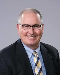 Tom Green commissioner man in suit with glasses smiling